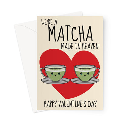 A cute Valentine's Day card featuring two smiling matcha latte cups with happy faces, placed in front of a red heart. The text reads "We’re a Matcha Made in Heaven" with "Happy Valentine’s Day" below.