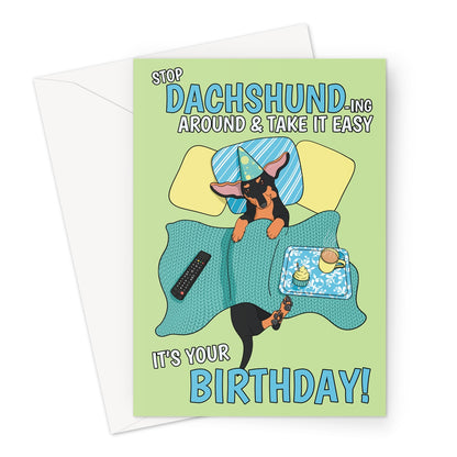 Illustrated Dachshund birthday card featuring a cute sausage dog in bed with a party hat, cupcake, and coffee, with the funny text "Stop Dachshund-ing Around & Take It Easy – It’s Your Birthday!"