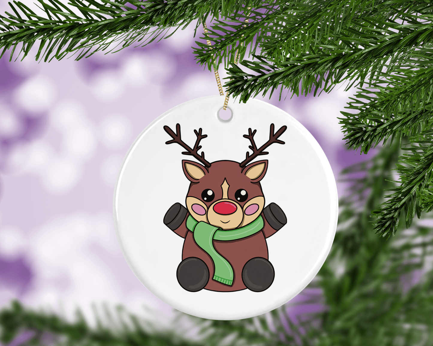 A round ceramic Christmas decoration to hang from a tree. Has a hand drawn illustration of a cute red nosed reindeer with a plain white background.